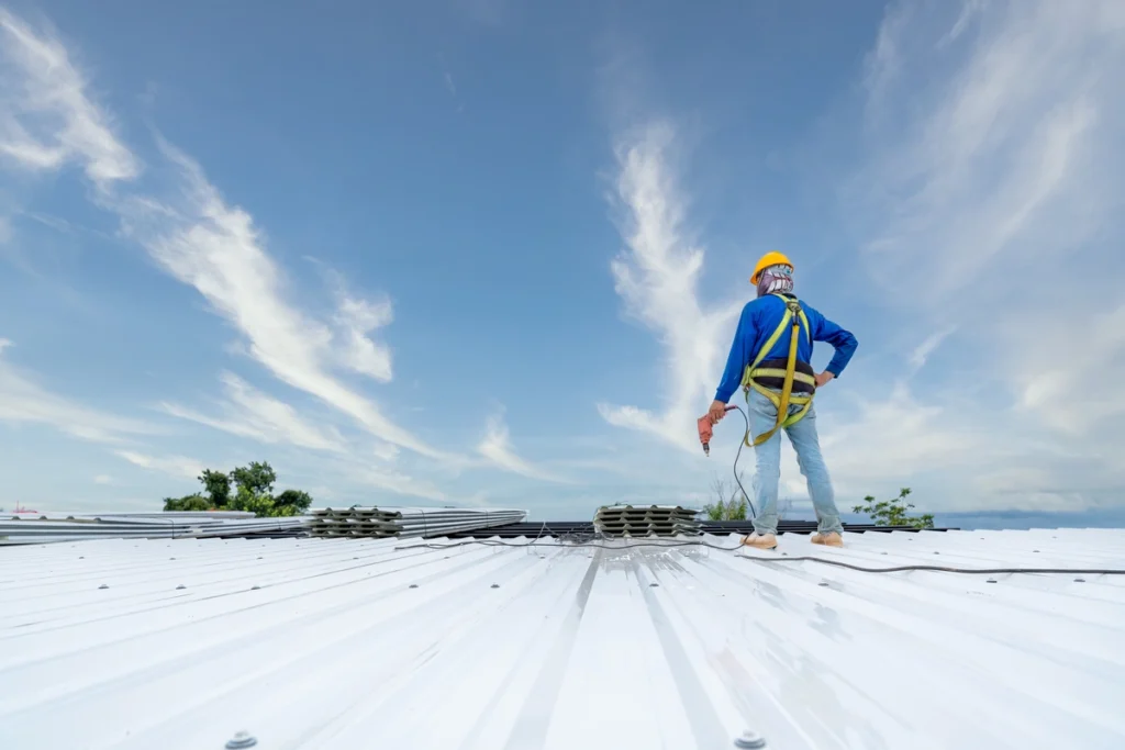 roofer stands on a commercial roof